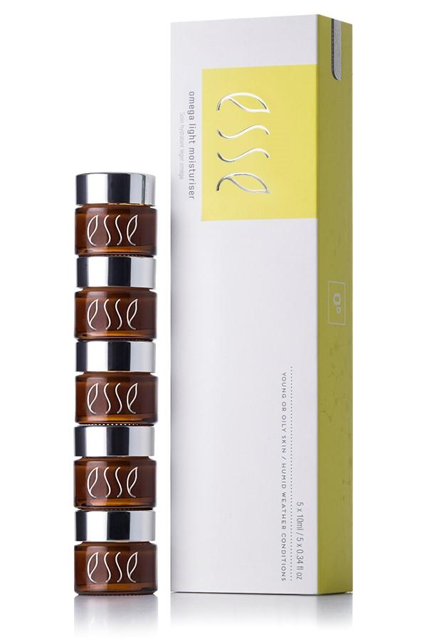 A stack of five brown jars with silver lids next to a white and yellow box labeled "Esse Omega Rich Moisturiser." Both the jars and the box display the "Esse" logo. The box also mentions that the product is for young or oily skin with mildly impaired barrier function.