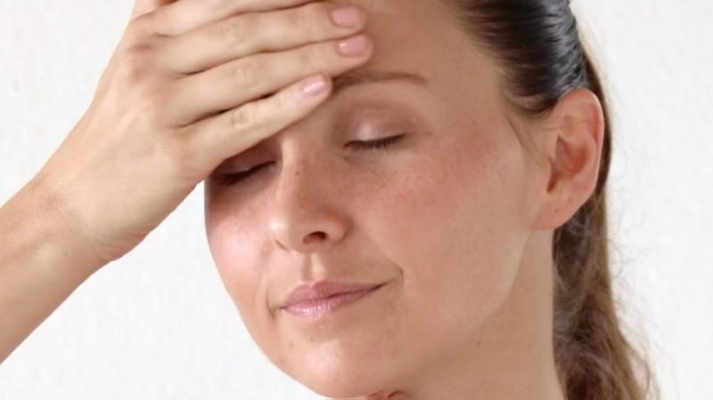 A person with closed eyes and a relaxed expression places a hand on their forehead, appearing calm and serene, likely benefiting from using the Esse Omega Rich Moisturiser. The background is plain and light-colored, emphasizing the peaceful moment.