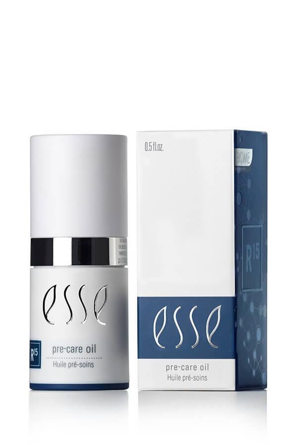 A bottle of Esse Pre-care Oil with a silver cap is shown beside its blue and white box labeled "Esse Pre-care Oil" and "R15" in the corner.